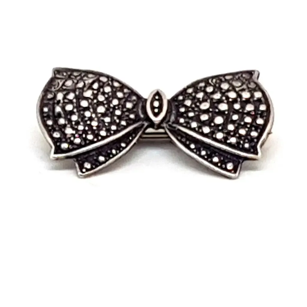 Vintage silver brooch in the shape of a bow in engraved silver. Circa 1960s. Jewelry.