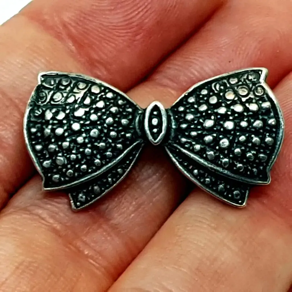 Vintage silver brooch in the shape of a bow in engraved silver. Circa 1960s. Jewelry.