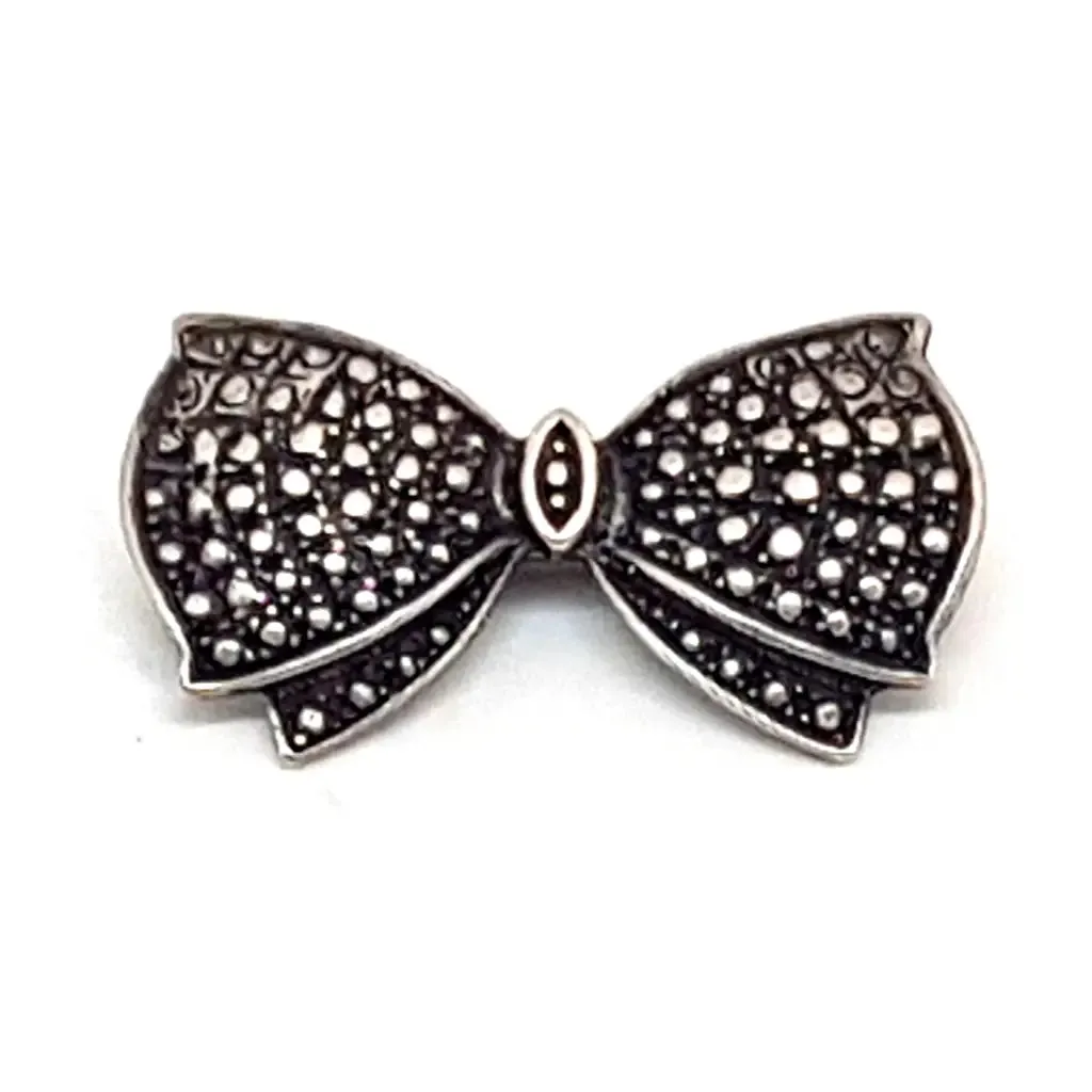 Vintage silver brooch in the shape of a bow in engraved silver. Circa 1960s. Jewelry.