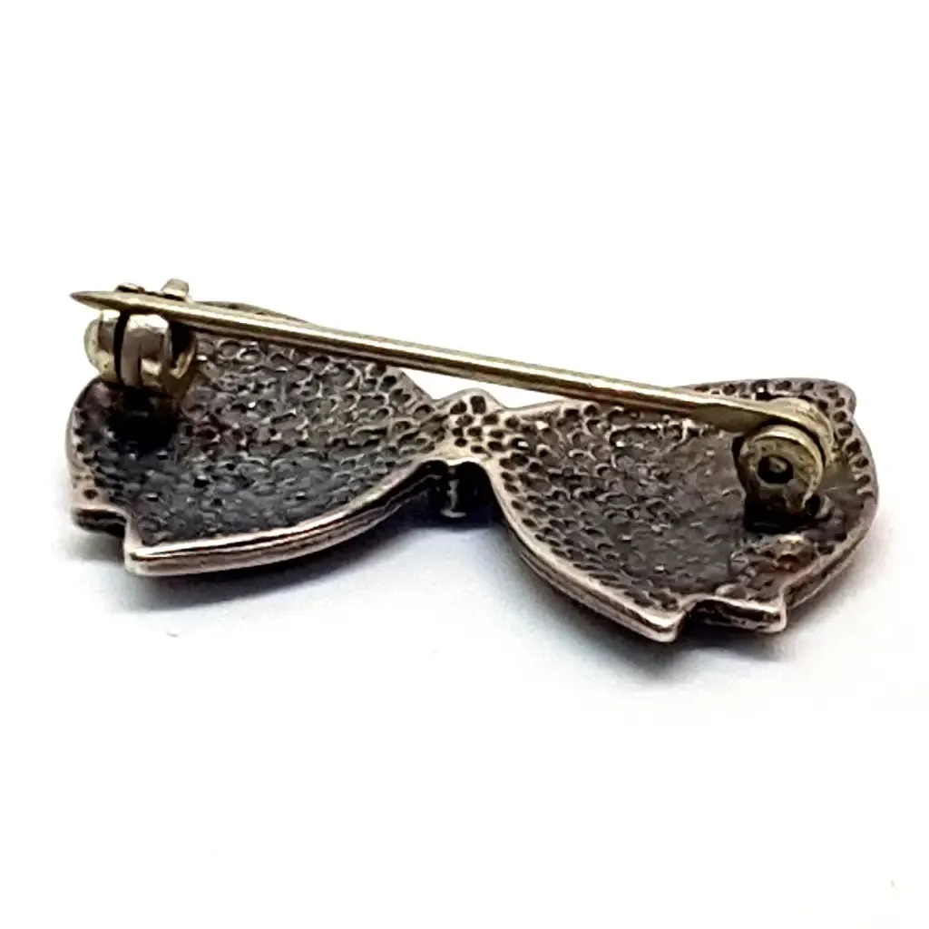 Vintage silver brooch in the shape of a bow in engraved silver. Circa 1960s. Jewelry.