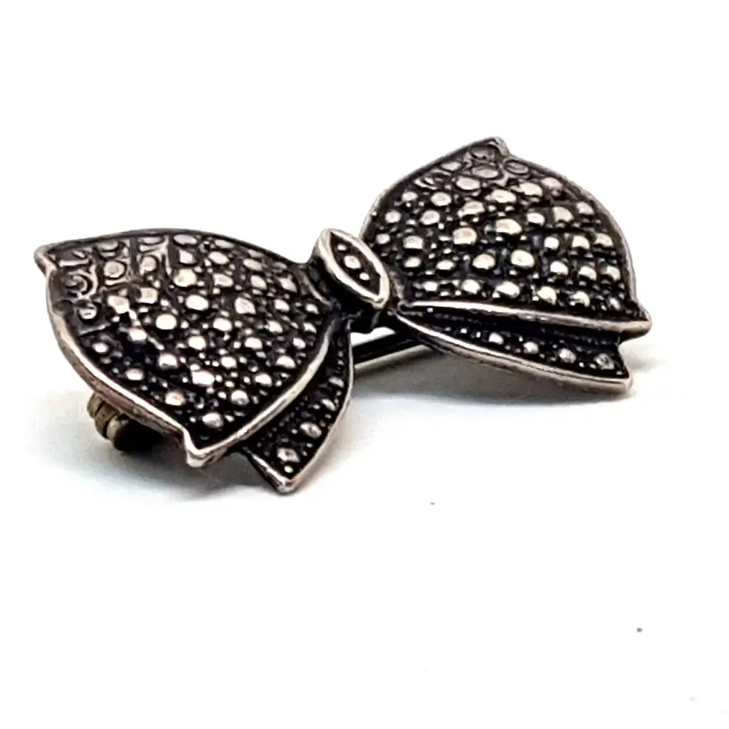 Vintage silver brooch in the shape of a bow in engraved silver. Circa 1960s. Jewelry.