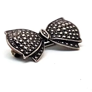 Vintage silver brooch in the shape of a bow in engraved silver. Circa 1960s. Jewelry.